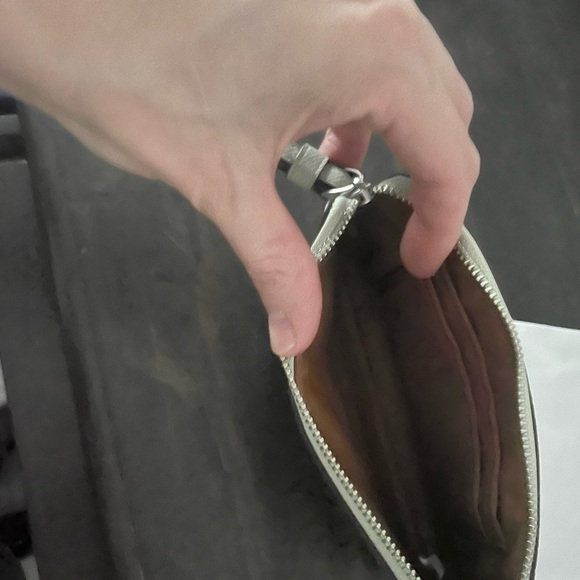 Light grey coach wristlet, with a silvery, gold coach written on it. - Picture 1 of 3